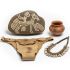 Collection of Khoisan cultural artifacts including a rock with painting, leather loincloth, ceramic pot, and ostrich egg bead necklace